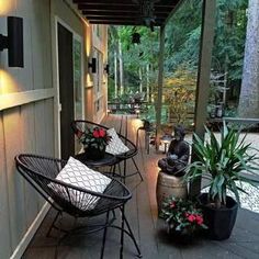 a porch with chairs and potted plants on it