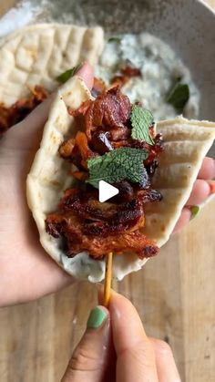 a person is holding a taco with meat on it