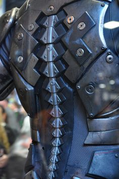 the back of a man's armor with spikes and rivets on it