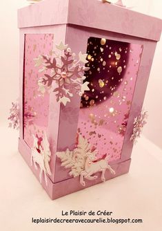 a pink gift box with gold glitters and paper snowflakes on the inside