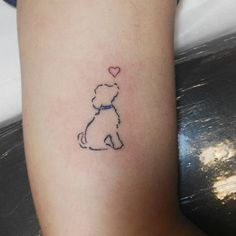 a small dog with a heart tattoo on its leg