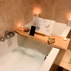 a bathtub with candles and a book on it