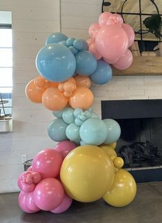 balloons are stacked on top of each other in front of a fireplace