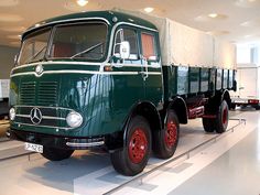 an old green truck is on display in a museum