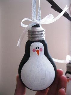 a bottle with a penguin painted on it and a ribbon tied around the top is being held by someone