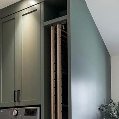 an oven built into the side of a wall in a kitchen with green cabinets and drawers