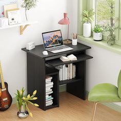 a laptop computer sitting on top of a desk next to a green chair and potted plant