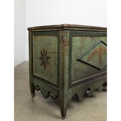 an old green cabinet with ornate carvings on it