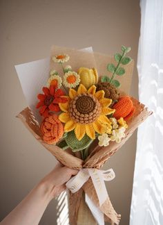 a person holding a bouquet of flowers in front of a window with the sunflowers on it