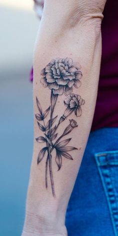 a woman with a flower tattoo on her arm