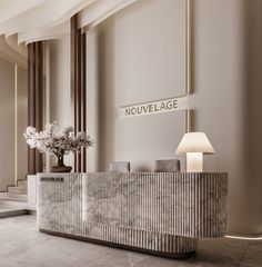 an elegant reception area with marble counter tops and white flowers in a vase on the table