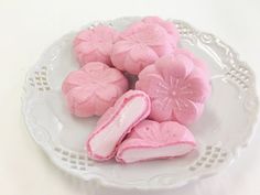 some pink cookies are on a white plate