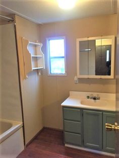 a bathroom with a sink, mirror and bathtub next to a shower stall in the corner