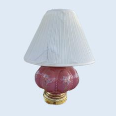 a red lamp with a white shade on it's base and a gold base