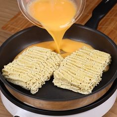 someone is pouring orange juice on some kind of food in a frying pan with two waffles