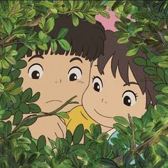 two children peeking out from behind some leaves