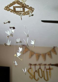 there is a wind chime hanging from the ceiling with white flowers and birds on it