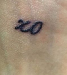 a small tattoo on the back of a woman's left arm with an o symbol