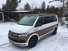 a white and brown van parked in the snow