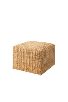 a small square wicker ottoman sitting on top of a white floor