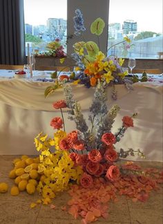 an arrangement of flowers on the floor in front of a table