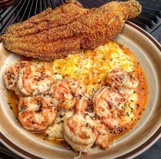 the meal is prepared and ready to be eaten on the grill with fish, shrimp, and grits