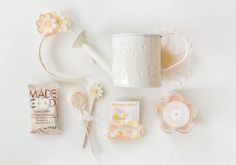 various items are arranged on a table including a watering can, flower headbands and paper flowers