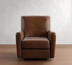 a brown leather chair sitting on top of a wooden floor