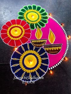 colorful diya with lit candles on the ground