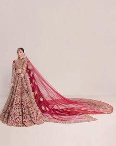 a woman in a red and gold bridal gown with long veil on her head