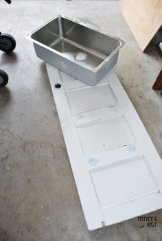 a metal sink sitting on top of a white door