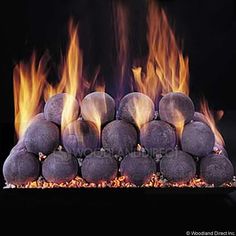 a close up of a fire with rocks on it's sides and flames in the background