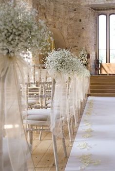 the aisle is decorated with white flowers and baby's breath