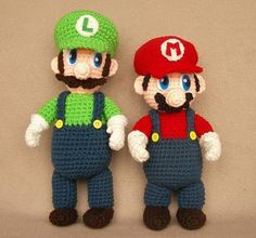 two crocheted mario and luigi amigurt dolls are standing next to each other