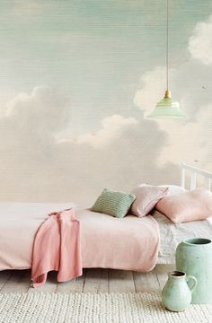 a bedroom with a pink bed and sky mural