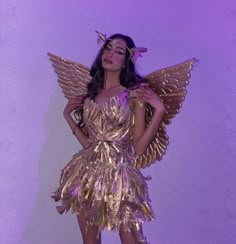 a woman in a gold dress with wings