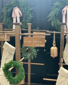 christmas stockings hanging from clothesline with personalized sign and wreath on door hanger