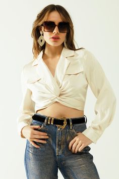 Introducing our Satin V-Neck Cream Crop Top – a versatile and chic addition to your wardrobe, ideal for the vibrant days of spring. This elegant crop top features a pristine white hue that effortlessly complements the season.  The allure of the V-neck neckline adds a touch of sophistication, creating a flattering frame for your neckline. Embrace the gentle embrace of long sleeves, making this crop top perfect for those cooler spring evenings.  Designed with a bodycon fit, this piece effortlessly accentuates your curves, offering a sleek and stylish look suitable for various occasions. The wrap front and knot detail add a playful yet refined touch, creating a unique and fashionable ensemble.  Crafted from luxurious satin, the fabric drapes gracefully, providing both comfort and a touch of o Elegant Crop Top, Crop Top With Long Sleeves, Cream Crop Top, Top With Long Sleeves, Color Crema, Neck Cream, Style Party, Top Crop, Running Tops