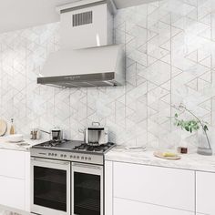 a stove top oven sitting inside of a kitchen next to white cabinets and counter tops