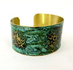 These unique, hand-formed copper and brass cuff bracelets with vibrant patinas create stunning accents to your personal style. Dress up or down- either way you'll be wearing an adornment that will turn heads, start conversations, and delight the eye of the beholder. This is a hammered Brass cuff with gorgeous marbled green/blue patina. Please note that patina colors will look different depending on the screen/device you view them on. This is a medium cuff- see measurements below. Cuffs have a 1” Handmade Brass Cuff Bracelet, Unique Brass Cuff Bracelet, Handmade Brass Cuff Bracelet Wearable Art, Handmade Brass Cuff Bracelet In Wearable Art Style, Bronze Brass Bracelet With Patina, Bronze Brass Bracelets With Patina, Patina Brass Bangle Bracelet, Brass Bangle Bracelet With Patina, Handmade Green Metal Cuff Bracelet