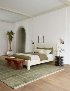 there is a large bed in the room with white walls and wood flooring on the side