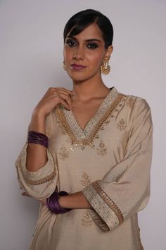 Ivory chanderi kurta with zardozi embroidered yoke. Comes with chanderi purple pant with embroidered hem and purple organza dupatta.
Component: 3
Pattern: Embroidered
Type Of Work: Zardozi Floral Motifs
Neckline: V-Neck
Sleeve Type: Three Quarter
Fabric: Kurta and Pant: Chanderi, Dupatta: Organza
Color: Ivory
Other Details: 
Lined kurta
Embroidered pant hem
Sequin and gota floral pattern on dupatta
Embroidered dupatta hem with fringed lace
Occasion: Puja - Aza Fashions Cream Gota Work Palazzo Set For Eid, Cream Palazzo Set With Gota Work For Eid, Eid Cream Palazzo Set With Gota Work, Cream Cotton Silk Set For Diwali, Transitional Cream Cotton Silk Sets, Elegant Cotton Silk Kurta With Gota Work, Festive Cream Sets For Transitional Season, Elegant Cream Palazzo Set With Gota Work, Designer Cotton Silk Cream Kurta