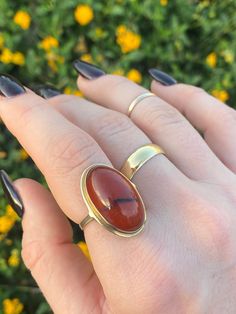 "This exquisite handcrafted statement ring adorned with amber glows from within. Designed in the timeless \"Arts & Crafts\" style, this ring features a stunning Amber cabochon centerpiece that captures the beauty of nature. It is crafted in 8k gold, which means it was likely made in Europe.  It has such a unique setting and the warm hues are mesmerizing.  To preserve the natural beauty of the Amber gemstone, avoid exposure to harsh chemicals and extreme temperatures. Clean gently with a soft, non-abrasive cloth. Hallmarks: \"333\" signifying 8k Weight: 4.32g US Size: 7.5 and sizable (fits bigger due to extra space under the amber) *Please note: other rings/jewelry pictured are for styling purposes only and are not part of this listing" Classic Amber Ring With Polished Finish, 14k Gold Oval Amber Jewelry, Classic 14k Gold Amber Jewelry, Gold Ring With Large Oval Cabochon Stone, Polished 14k Gold Amber Jewelry, Classic Amber Ring Jewelry, Formal Carnelian Oval Cabochon Jewelry, 14k Gold Amber Jewelry With Polished Finish, Gold Citrine Jewelry In Oval Cabochon Shape