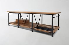 the table is made out of wood and has metal straps on each side, with two trays underneath it