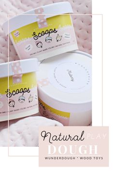 three jars of soap sitting on top of a pink blanket