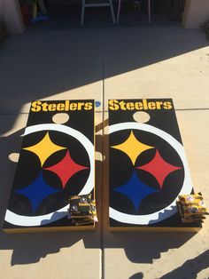 two cornhole game boards sitting on top of a cement floor next to each other