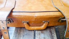 a brown leather suitcase sitting on top of a wooden table