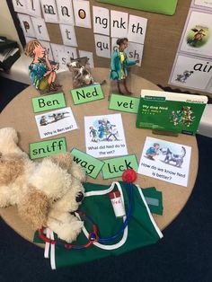 there is a teddy bear on the table with some books and toys around it,