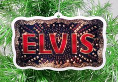 an ornament hanging from a christmas tree with the word elvis written on it