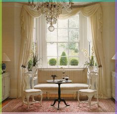 a living room filled with furniture and a chandelier hanging from the side of a window